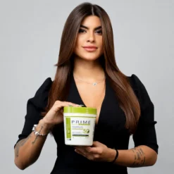 Modelo segurando a Prime Pro Extreme Bio Tanix Repair Mask 1kg, máscara de reparação capilar profissional para hidratação, reconstrução e fortalecimento dos fios.